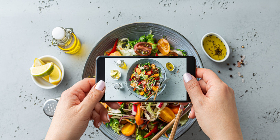 femme en train de prendre en photo avec son smartphone son repas 